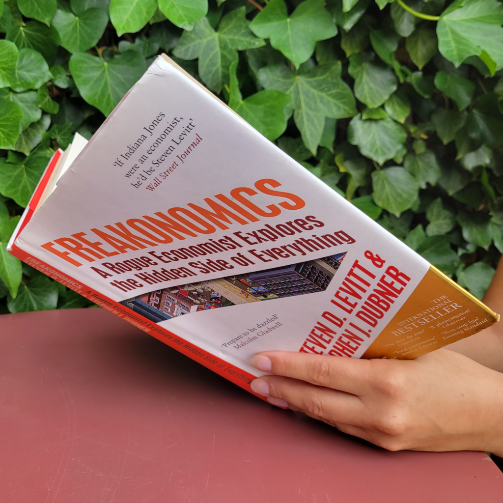 A woman reading Freakonomics: A Rogue Economist Explores the Hidden Side of Everything by Steven D. Levitt and Stephen J. Dubner