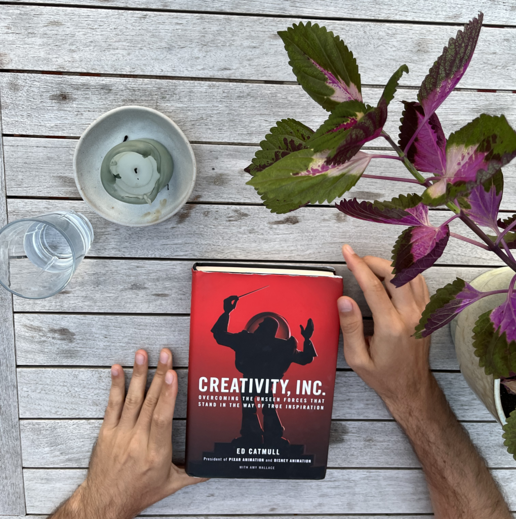 Creativity, Inc. by Ed Catmull being held by a man sitting at a table.